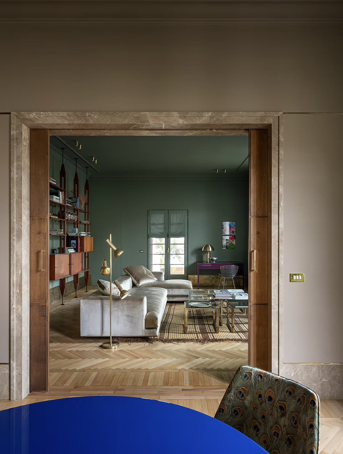 View into green living room with a modular sofa and glass coffee table.
