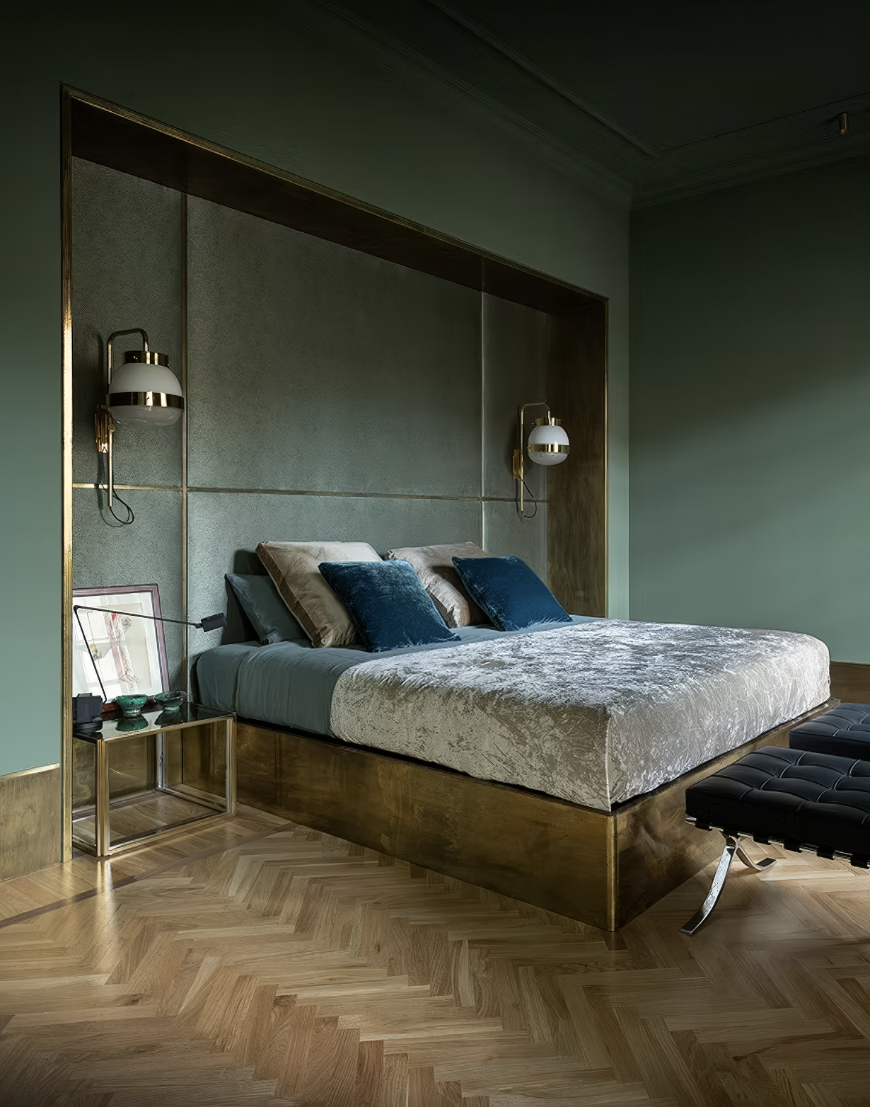 Luxe bedroom with velvet bed, deep green walls, and gold alcove.