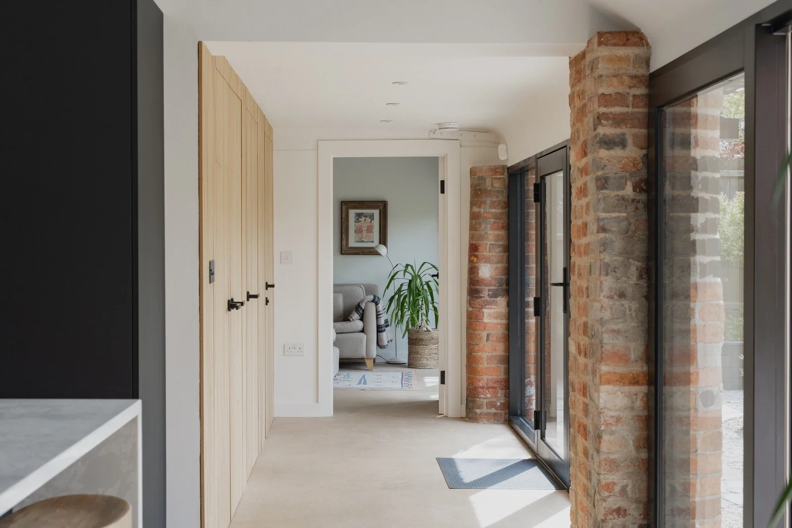 fen-barn-light-filled-hallway-with-exposed-brick-and-doors.jpg