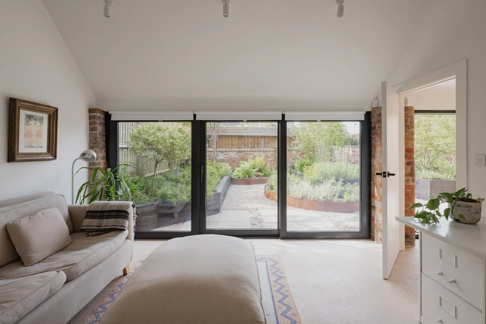 fen-barn-bedroom-with-garden-view-through-black-doors.jpg