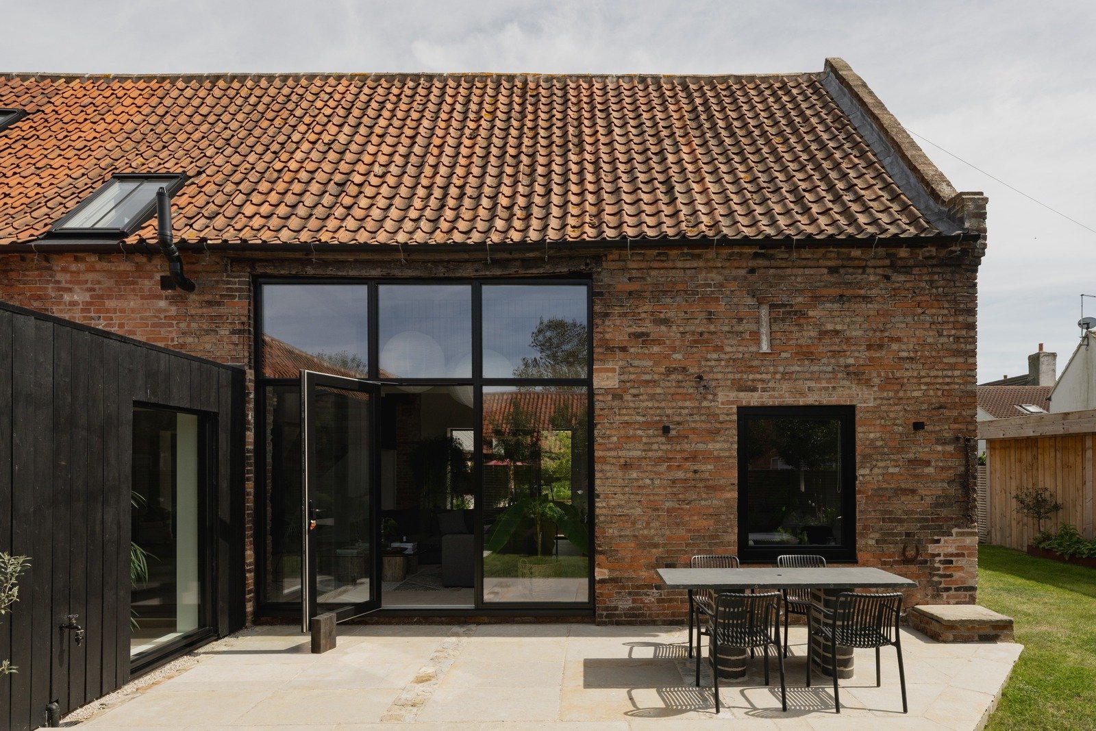 fen-barn-redbrick-facade-with-black-doors-and-outdoor-dining.jpg
