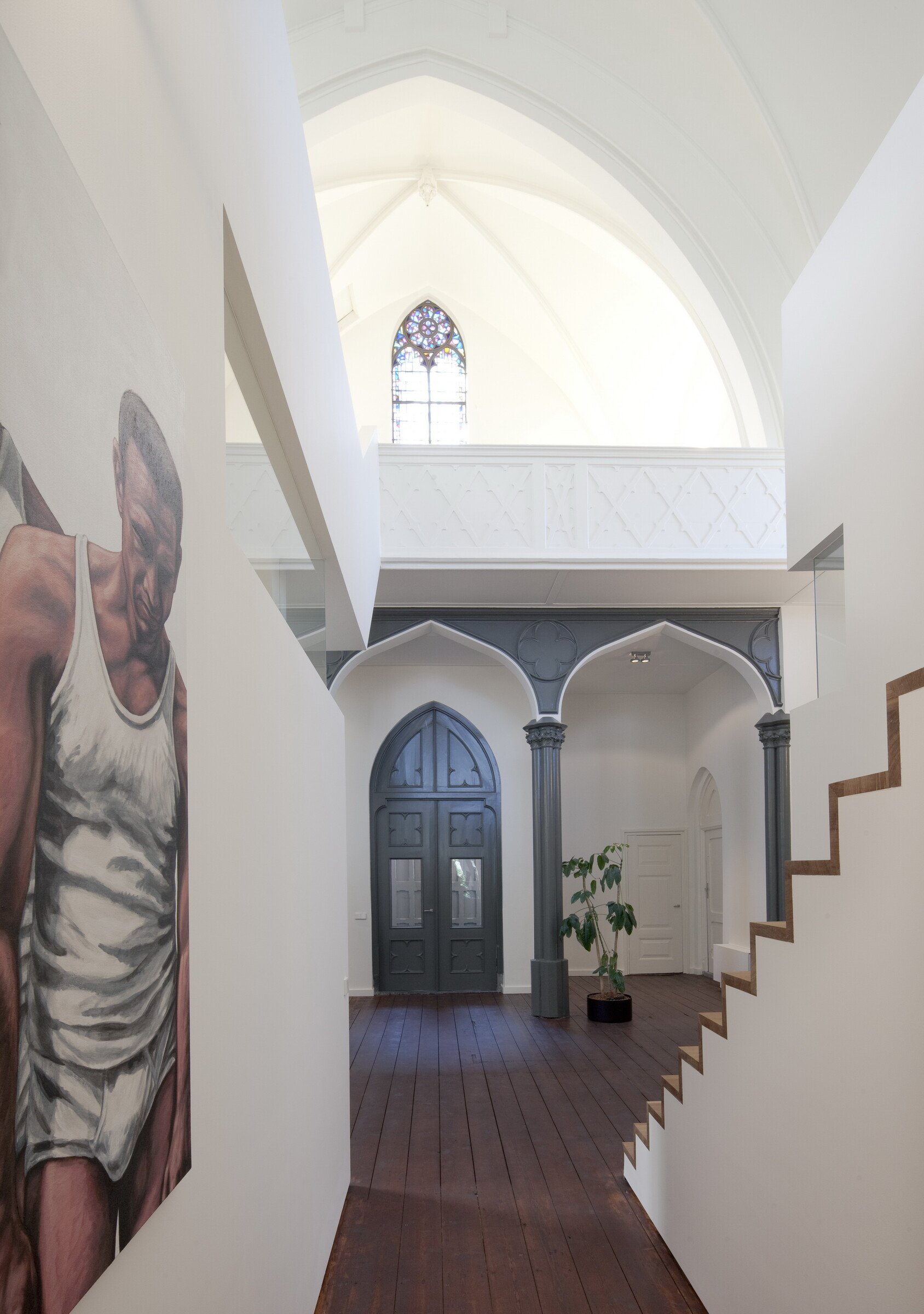 Utrecht church converted into a home with original wooden floors and sleek freestanding living pod under historic arches.