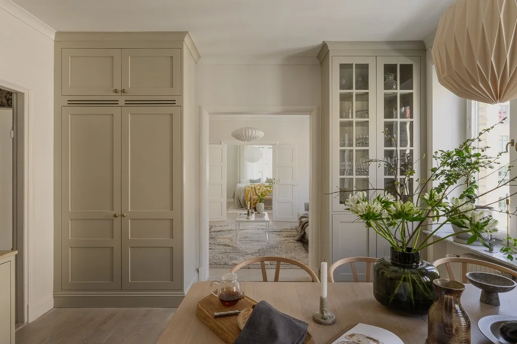 Elegant Scandinavian Kitchen with Glass-Front Cabinets and Blooming Branches