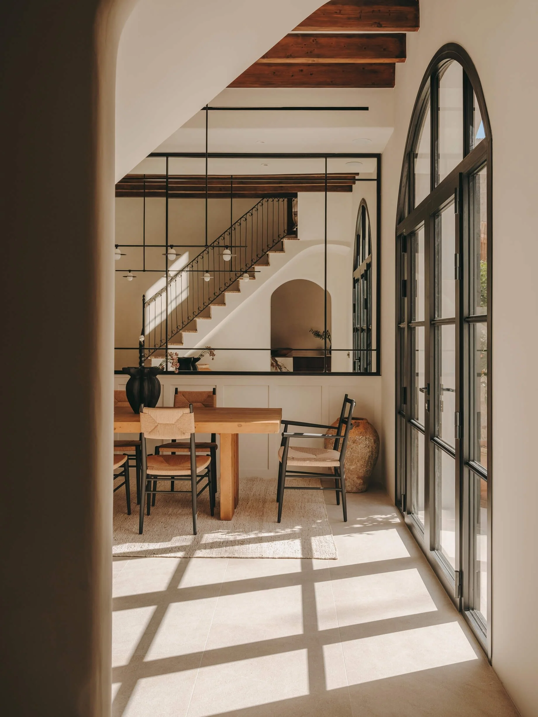 contemporary dining area with natural wood table and chairs with a view overlooking the pool.