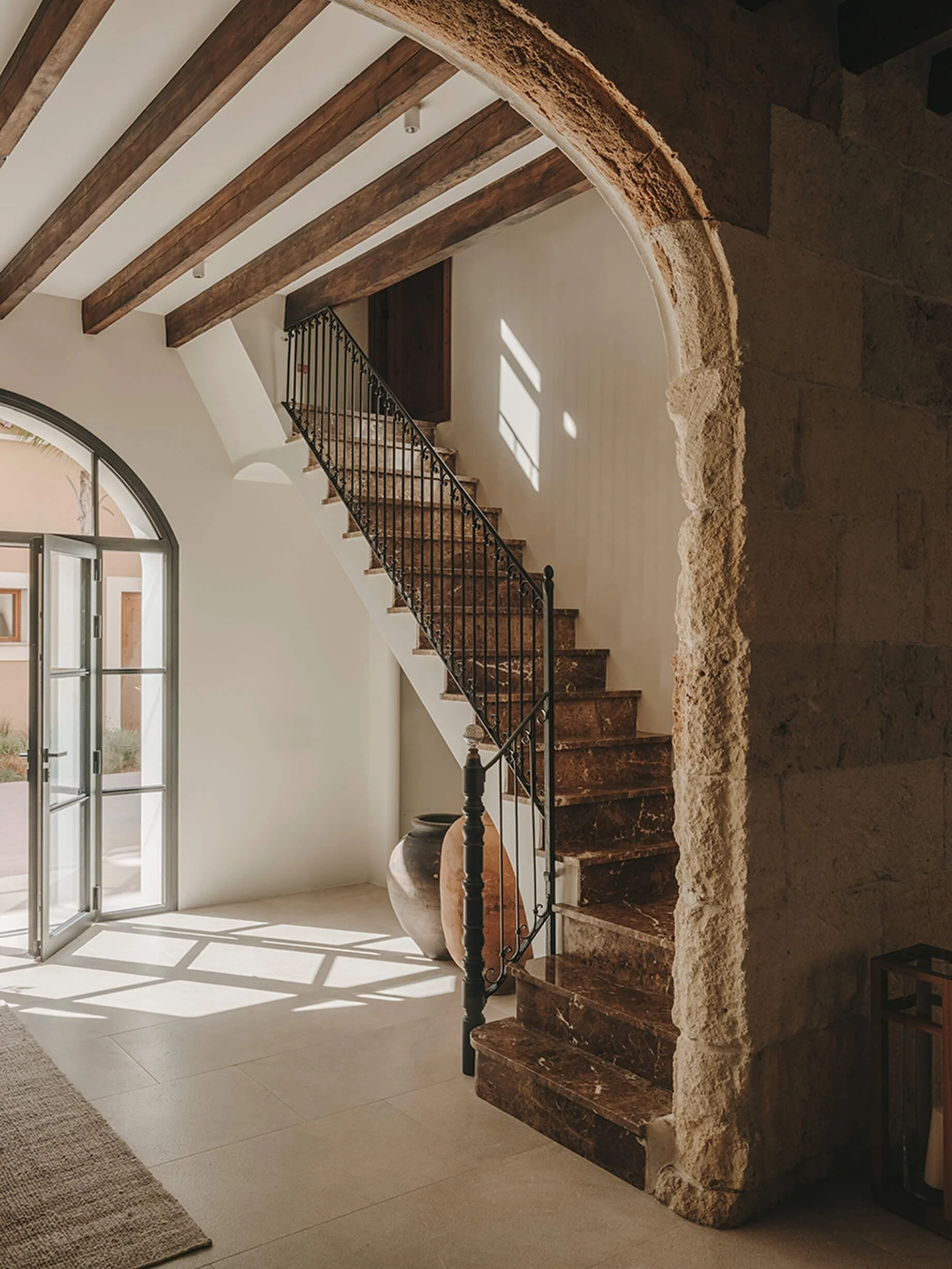 Showcasing the marble staircase and the rustic old stone walls of the entryway.