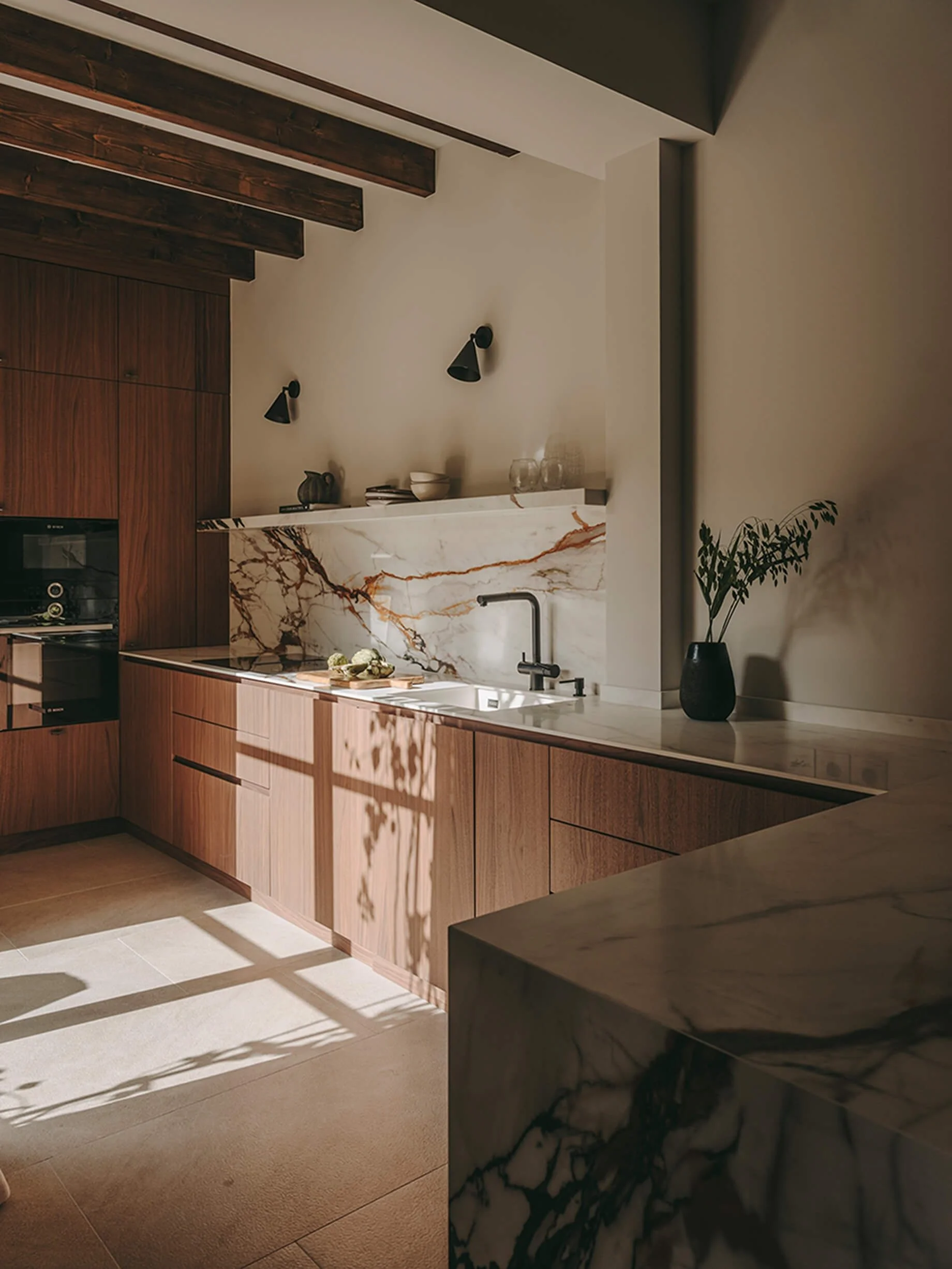 View of the rustic kitchen with light flooding through and beamed ceiling.
