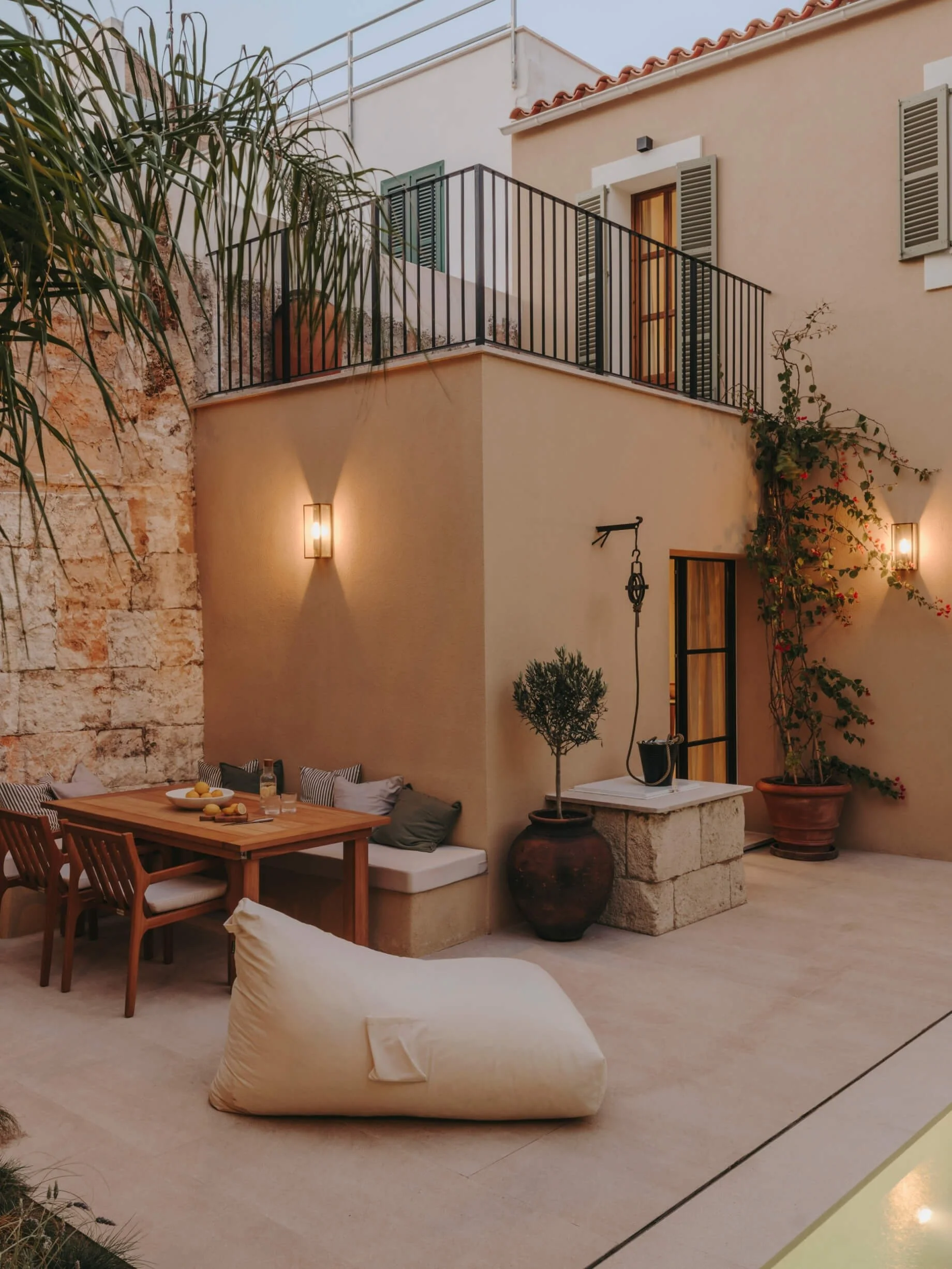 Outdoor dining area, seating built into the external wall and exposed brickwork mixed with modern neutral coloured render.