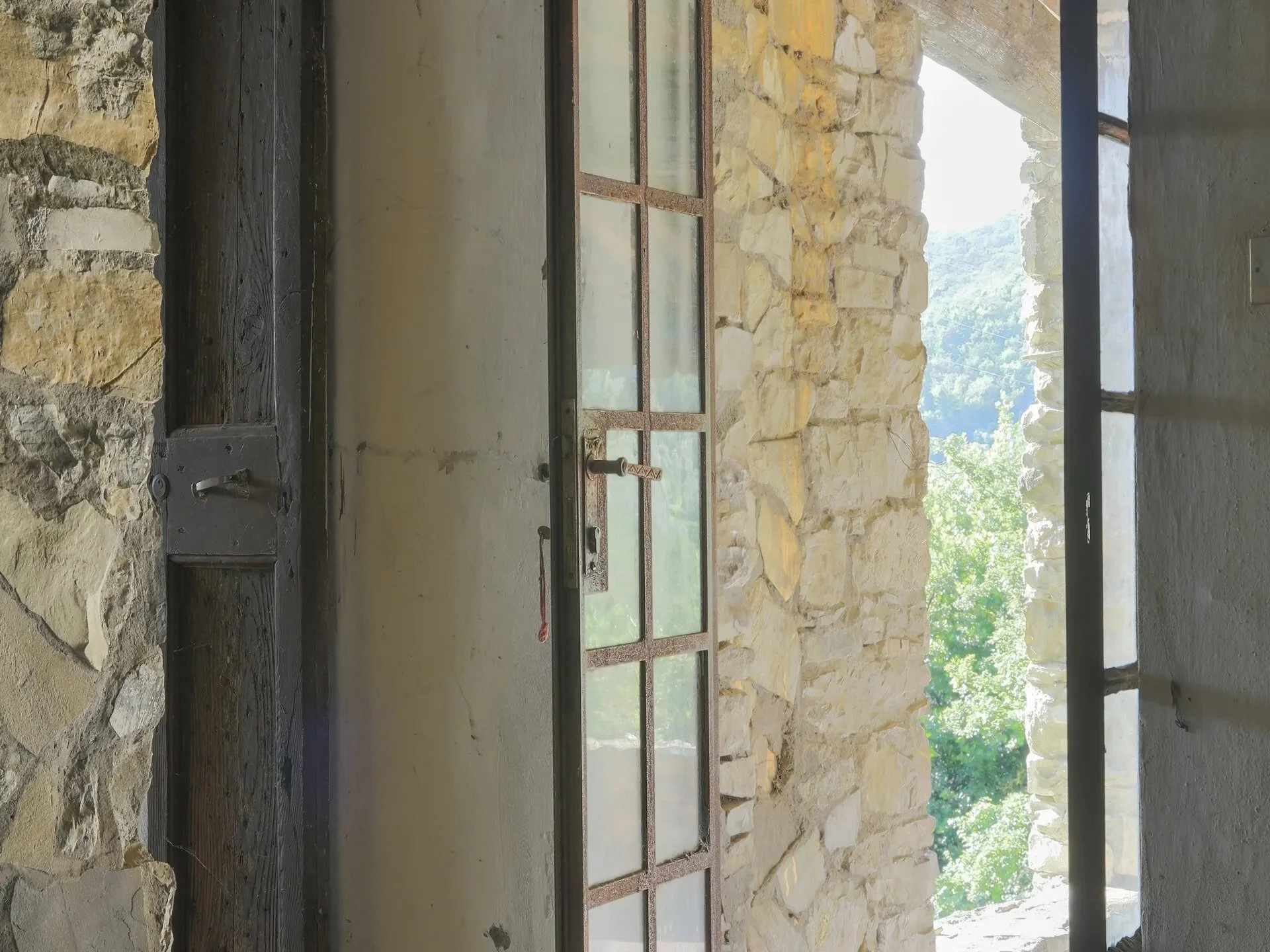 sunlit-doorway-of-tuscan-farmhouse-looking-out-to-valley.jpg