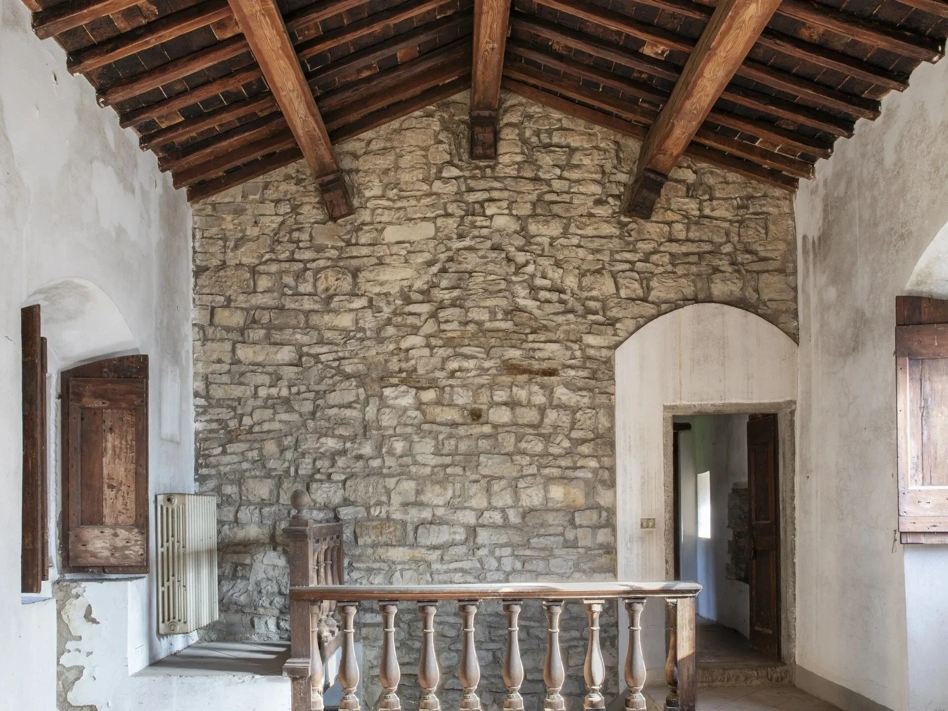 interior-stone-wall-and-wooden-railing-in-ancient-tuscan-farmhouse.jpg
