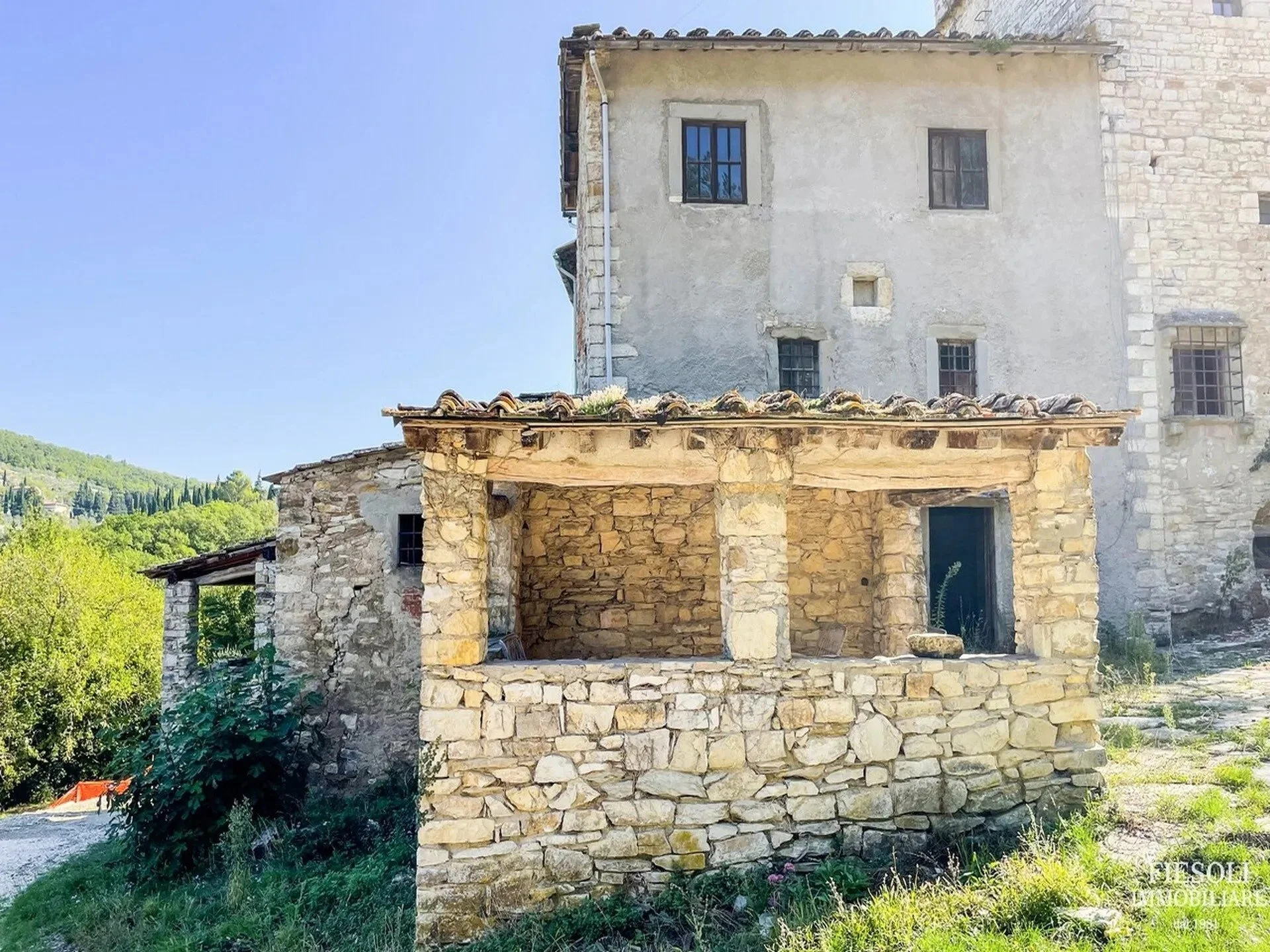 stone-outbuilding-of-medieval-tuscan-home-under-clear-blue-sky.jpg