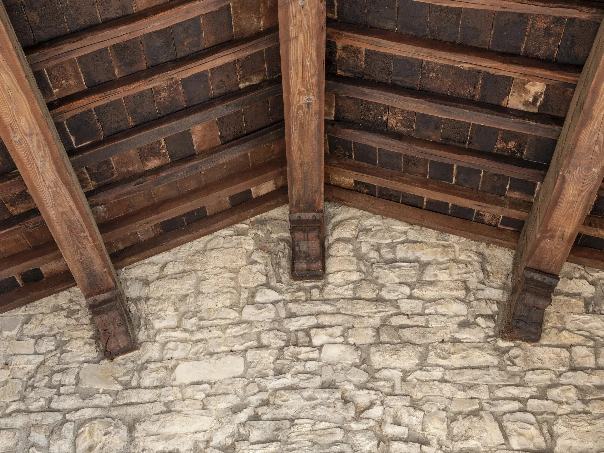 tuscan-stone-wall-with-dark-wooden-ceiling-beams.jpg