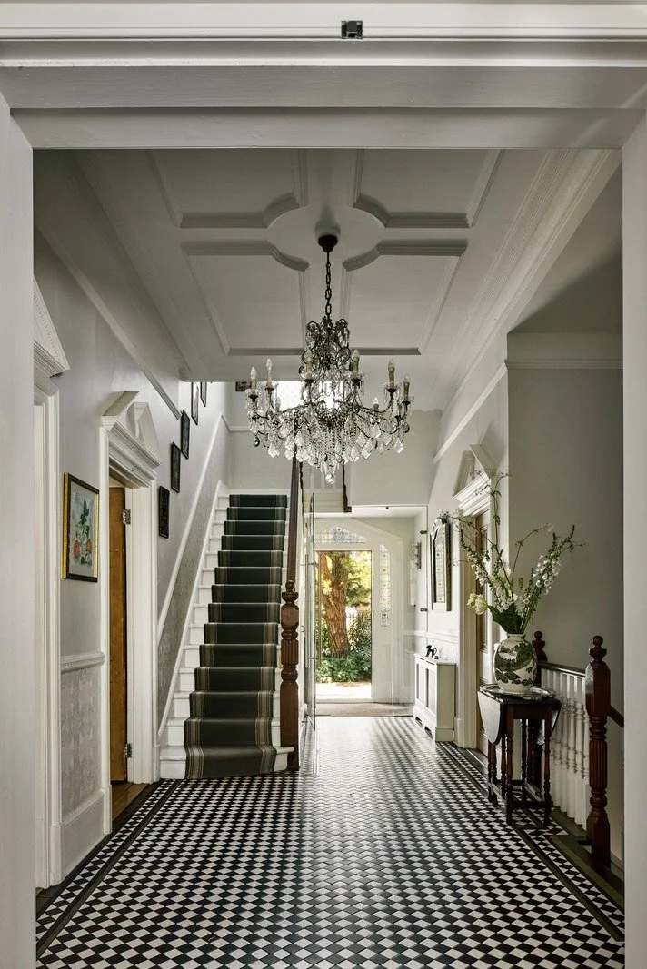 long-victorian-hallway-checkerboard-tile-floor-and-grand-staircase-london-home.jpg
