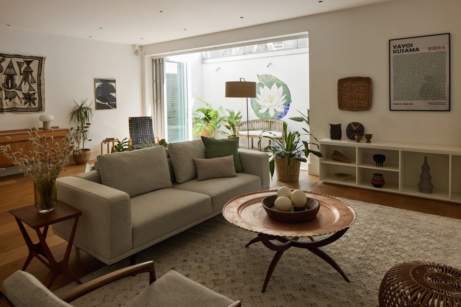 mid-century-modern-living-room-soft-grey-sofa-lotus-wall-mosaic-plants.jpg