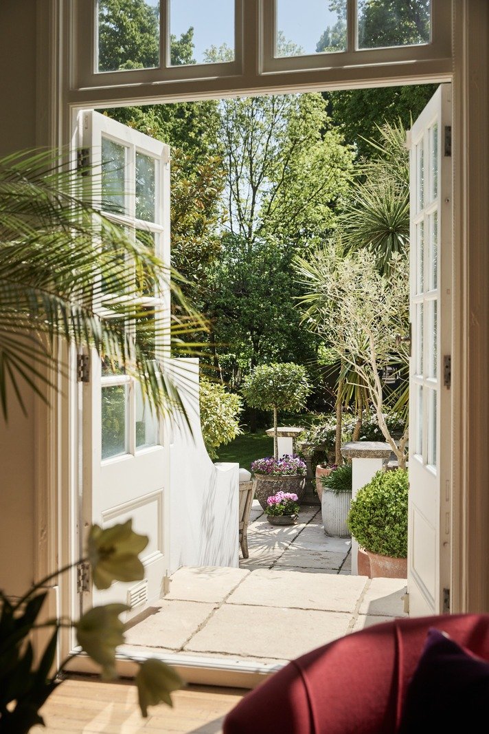 garden-terrace-view-through-french-doors-with-potted-topiary-and-stone-flooring.jpg