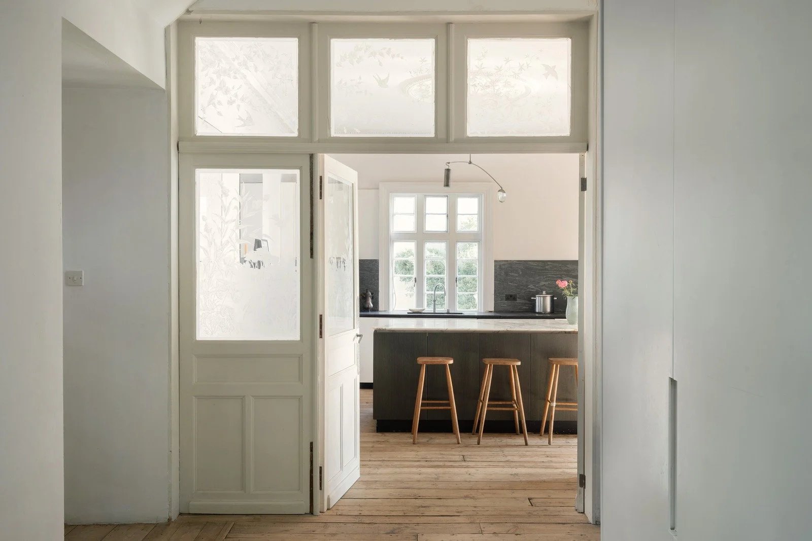 From the reception room with floor-to-ceiling library and into the spacious kitchen.