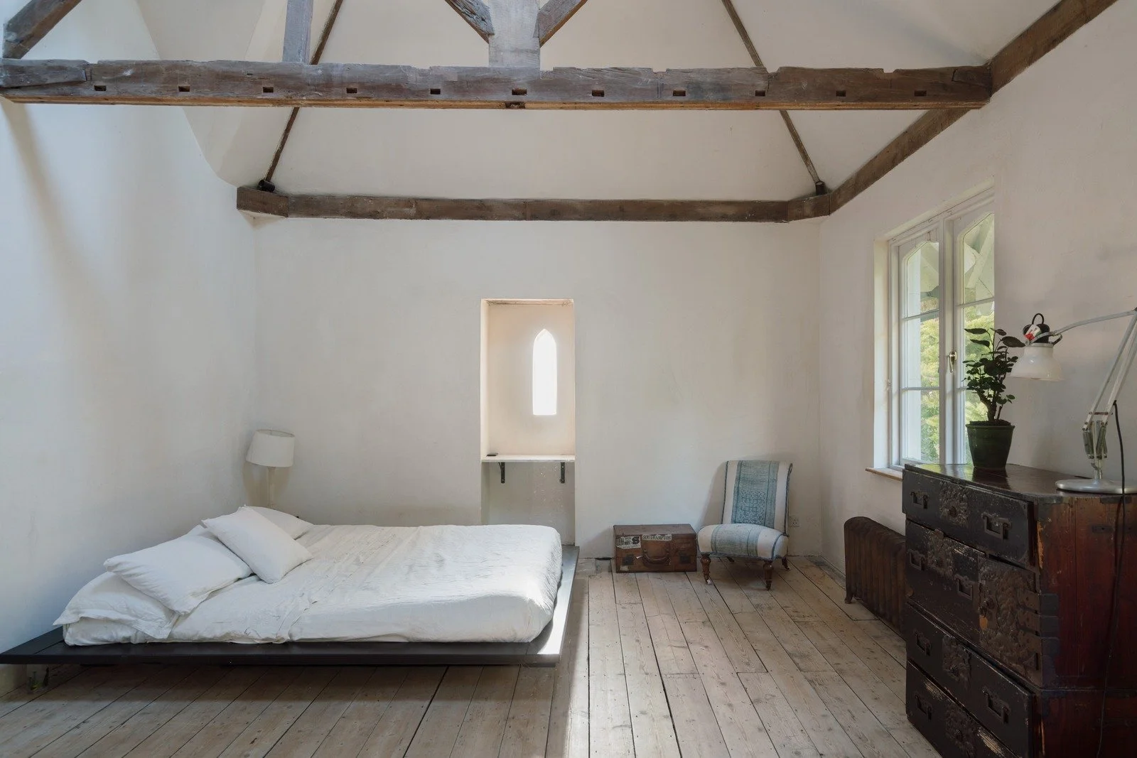 Principal bedroom showcasing freestanding bathtub and exposed beams.