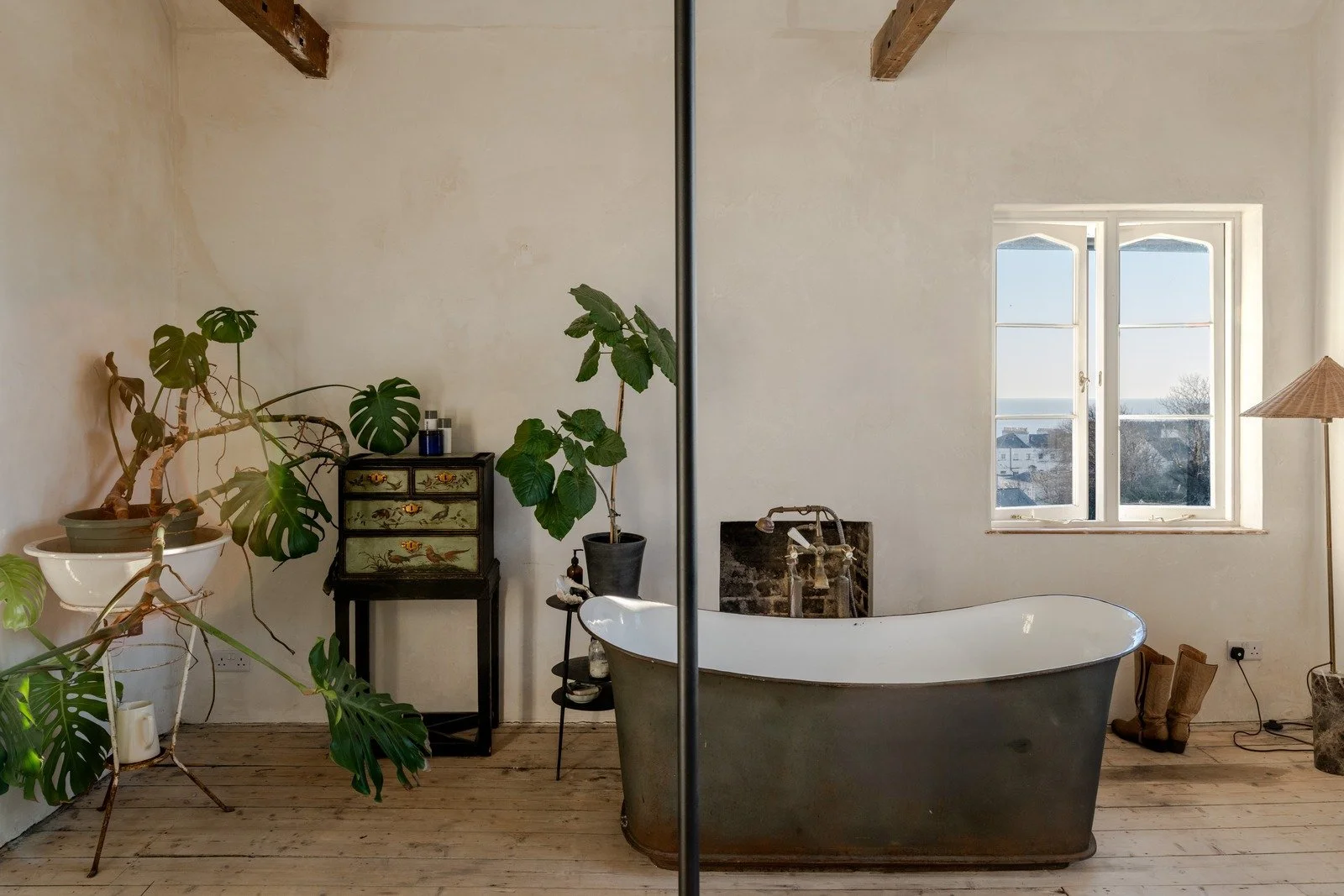 Principal bedroom showcasing freestanding bathtub and exposed beams.