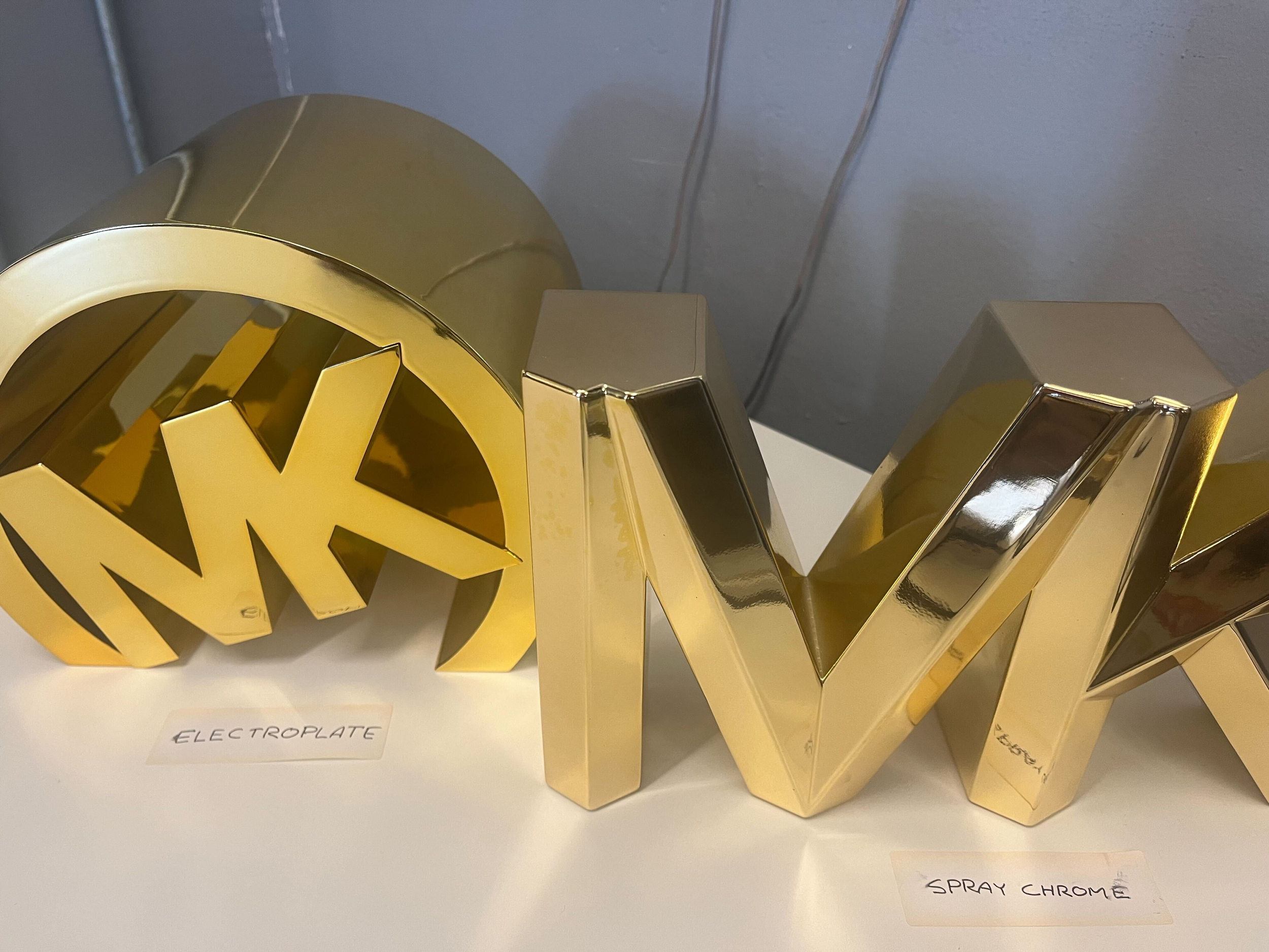 Decorative golden letter W and part of the letter S with labels reading 'ELECTROPALTE' and 'SPRAY CHROME' underneath.