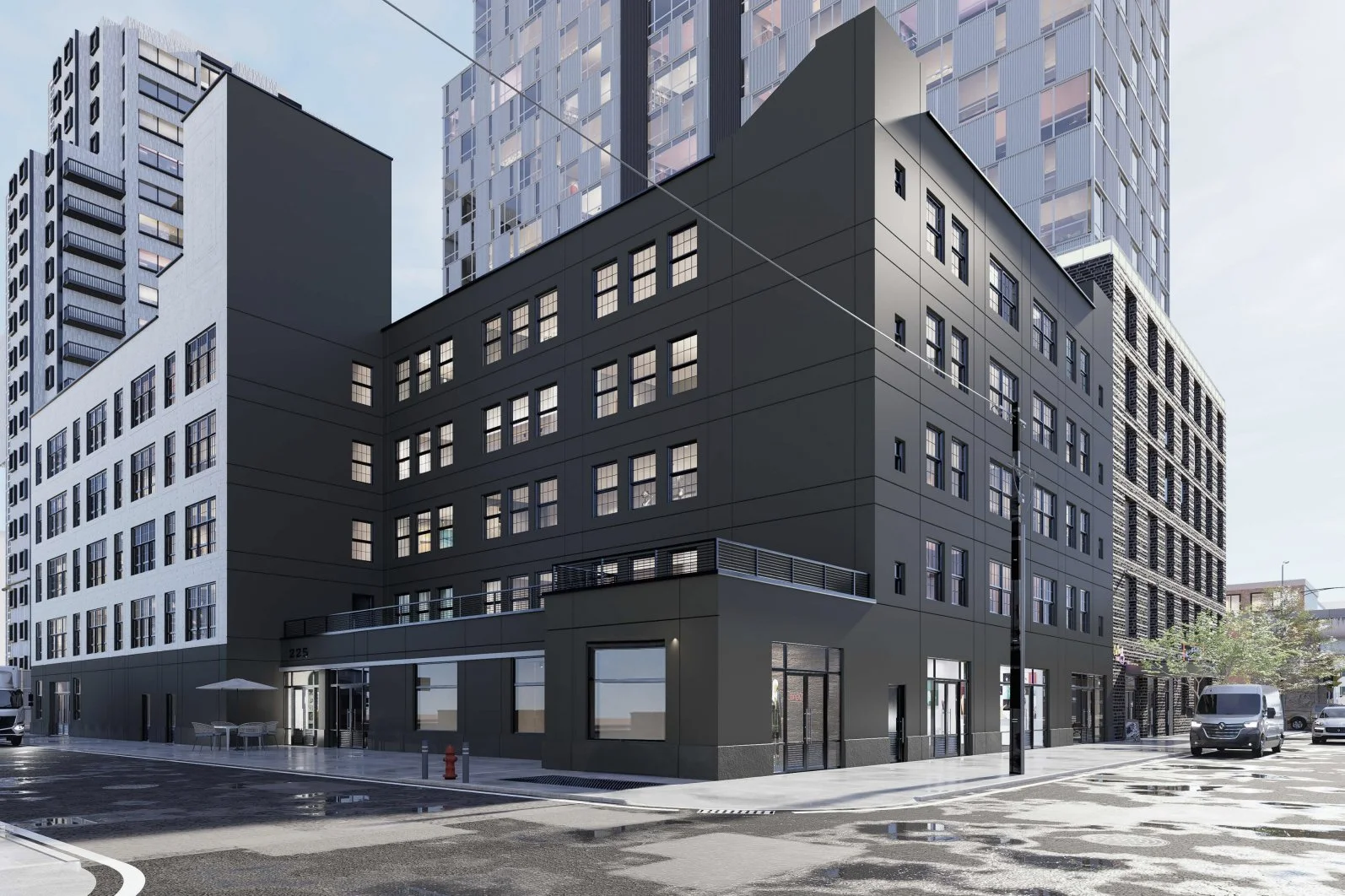 A modern black and white multi-story building on a city street with parked cars and trees, during daytime.