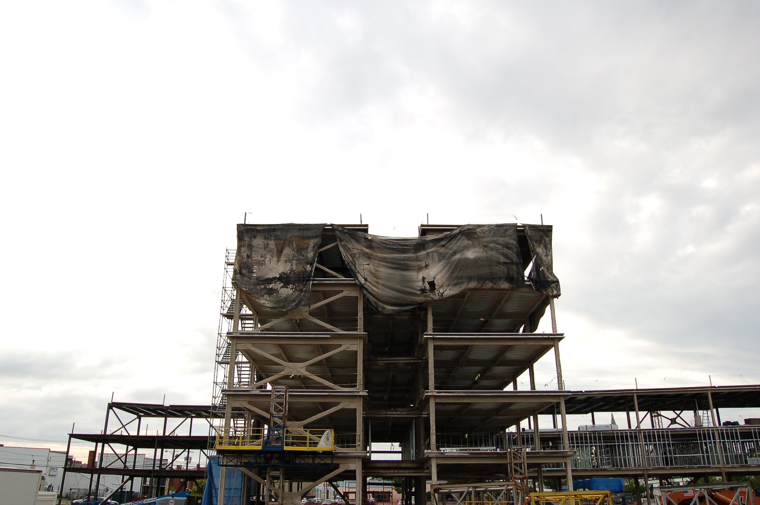 Construction site with a building framework and scaffolding under cloudy sky