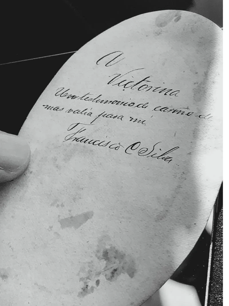 Carta manuscrita en papel envejecido que dice: 'A Victoria, contemplando el camino de nuestras vidas para mí. Francisco Silva'.