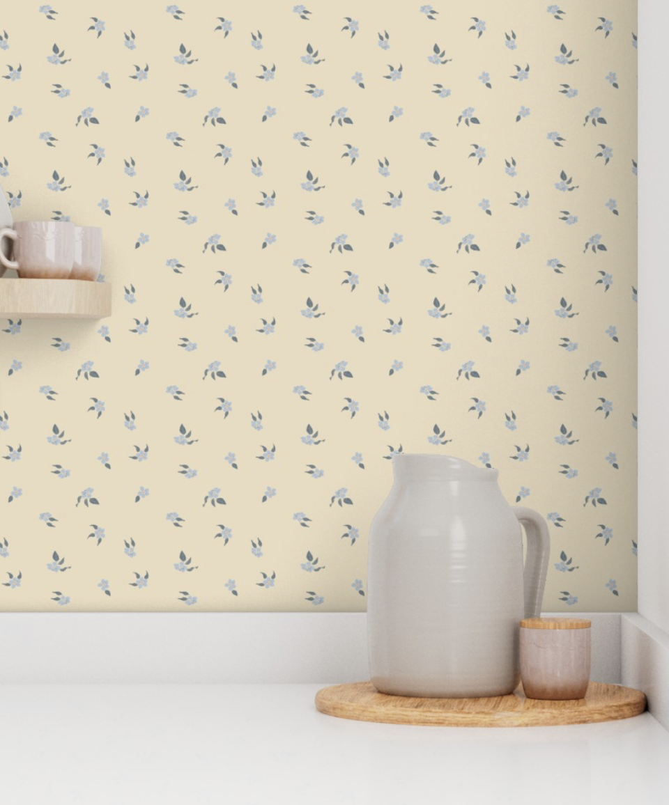 A kitchen scene with a white pitcher and small mug on a wooden tray in front of a wall with pale yellow wallpaper with small blue floral patterns.