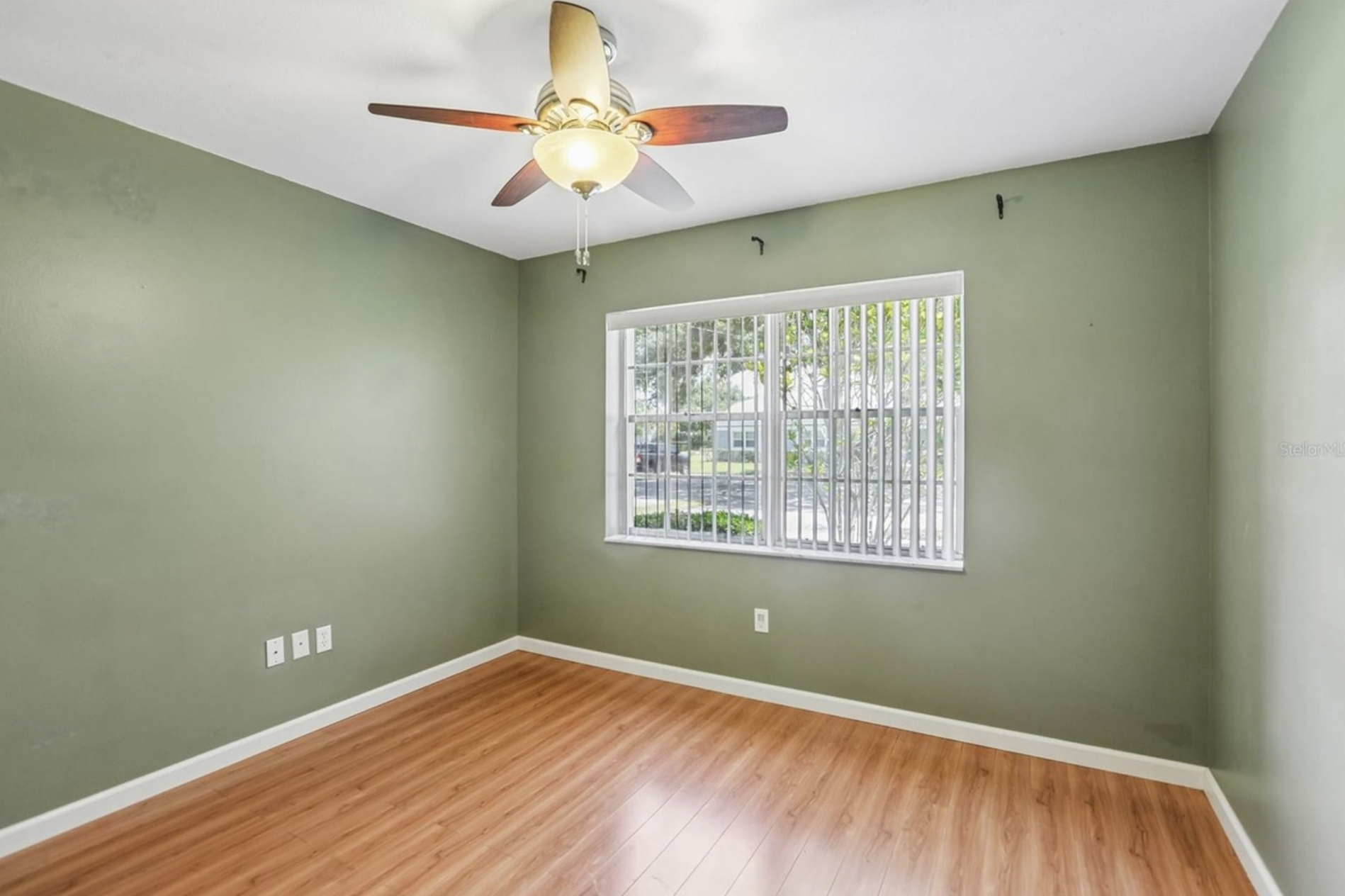 Bedroom #1 has a ceiling fan and view of the front of the villa.