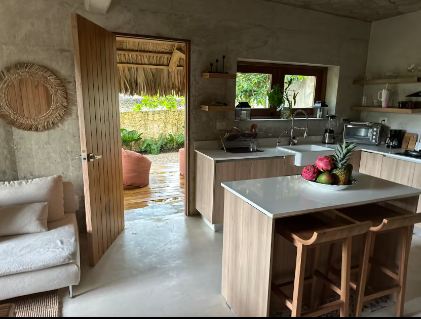Open kosher kitchen with stone island, bar seating, and garden view at a luxury villa, Dominican Republic