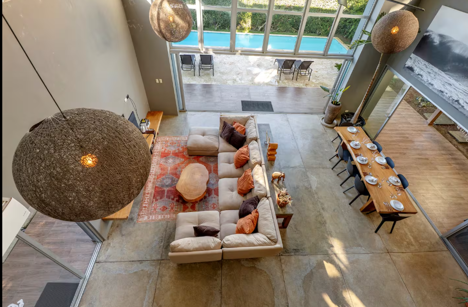 Aerial view of open-plan living and dining area with pool visible through glass doors at a kosher luxury villa, Dominican Republic