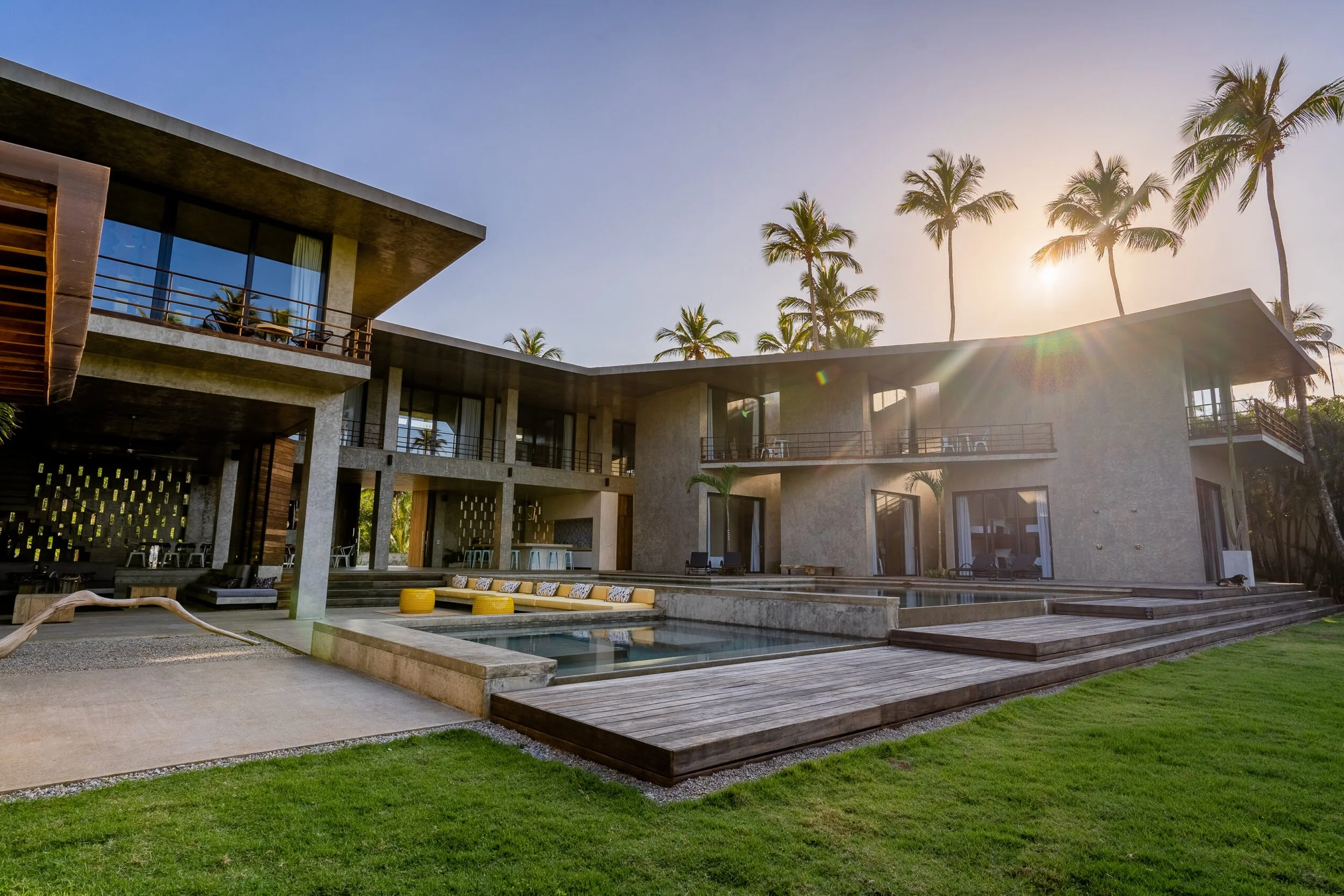 Modern kosher luxury villa exterior at sunset with pool deck and palm trees, Dominican Republic