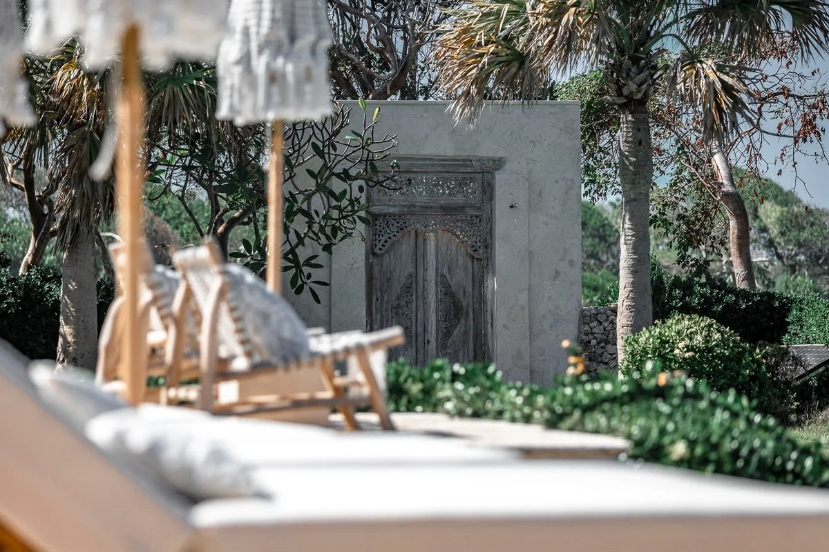 Luxury villa outdoor lounge with comfortable seating surrounded by lush tropical gardens.