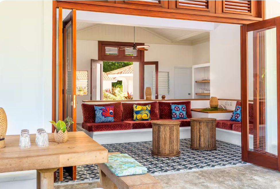 Luxury Caribbean villa interior with an open-plan kitchen, colorful tile backsplash, wood accents, and tropical views in the Dominican Republic.