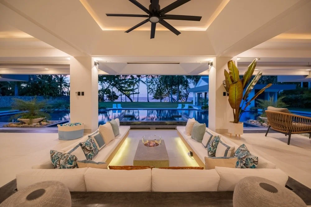 Luxury villa living room with a modern lounge, private pool views, and tropical surroundings in the Dominican Republic.