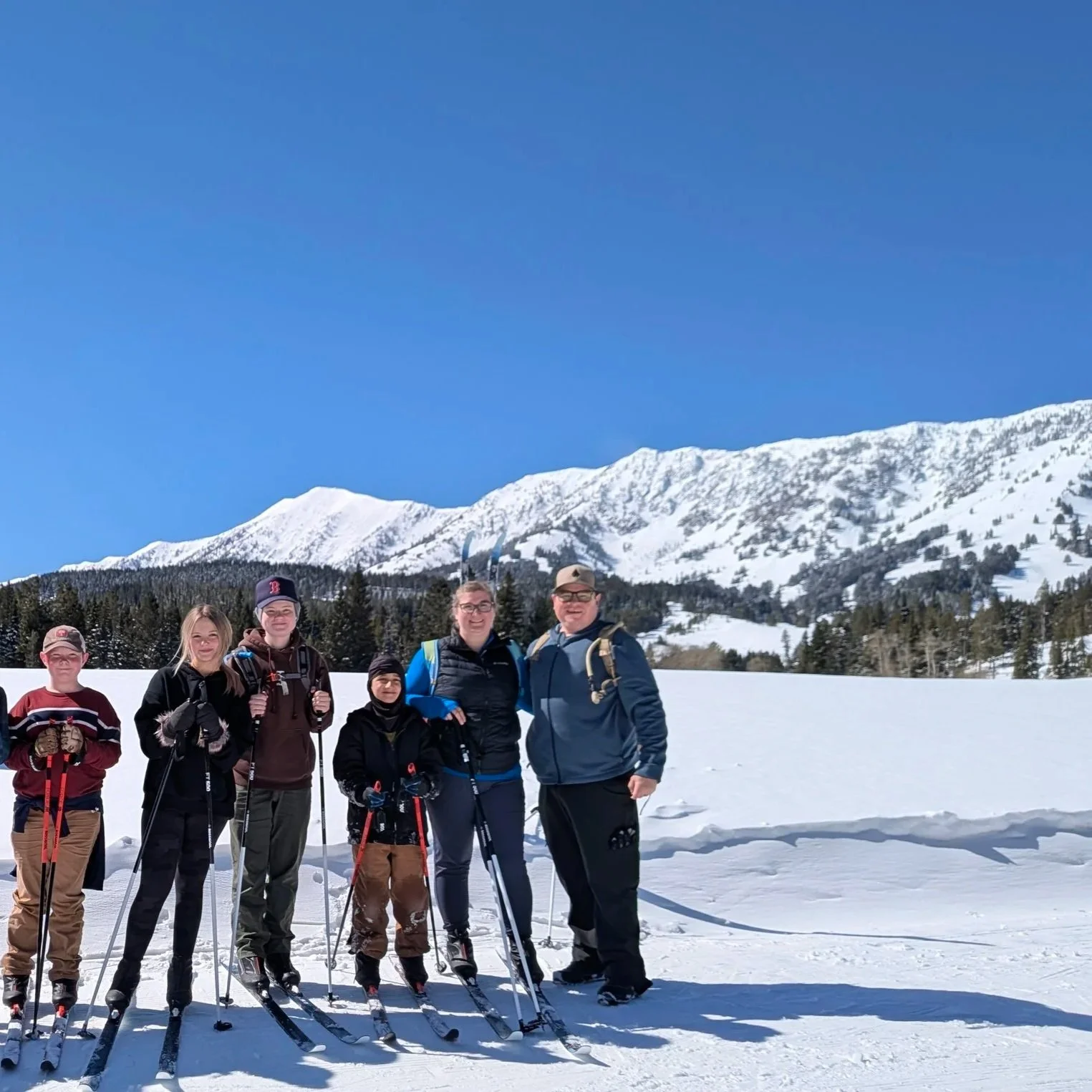 Family on skiis with mountain in background