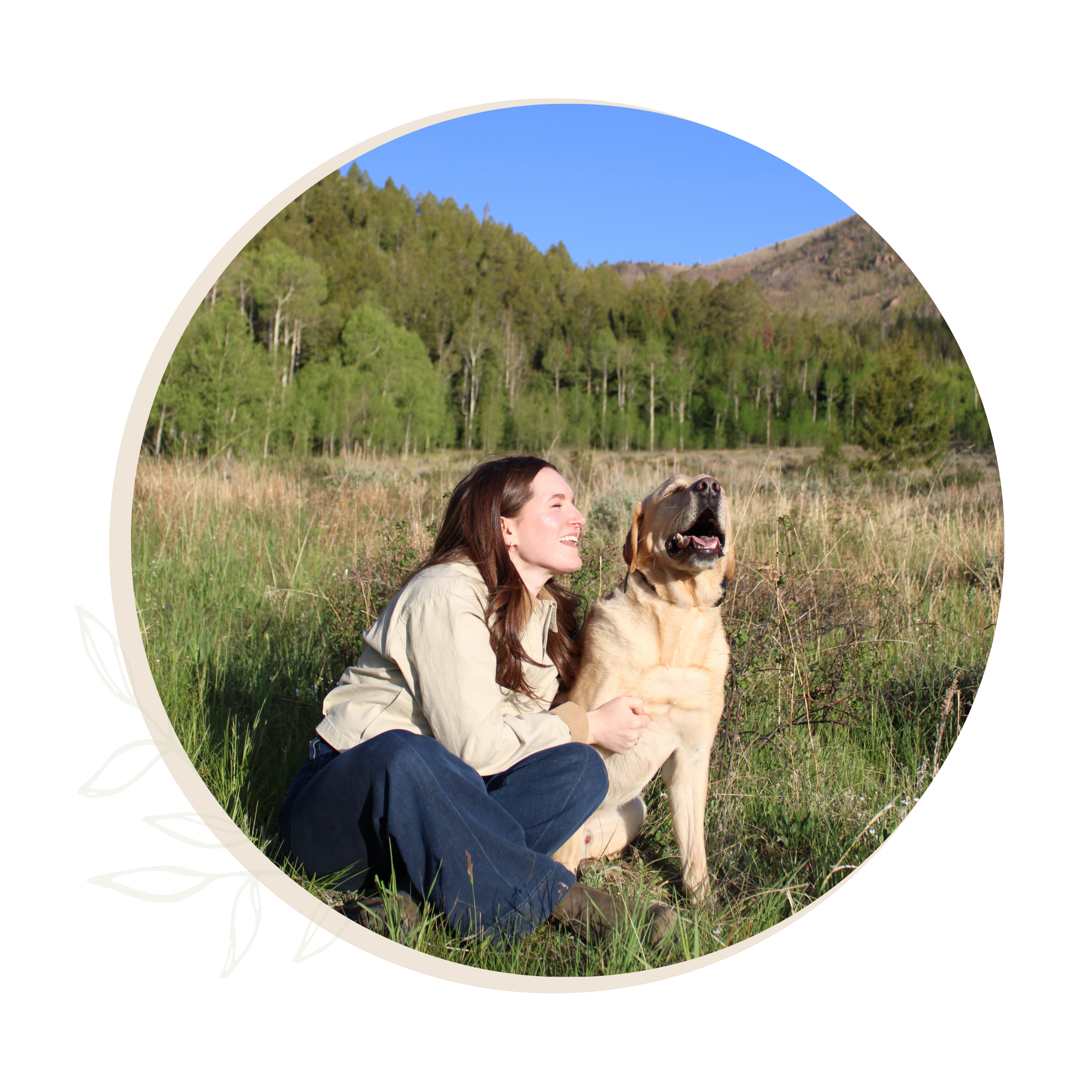 Laura Landrum, EMDR therapist in Summit County, Colorado, sitting in a grassy field beside a golden retriever with trees and mountains in the background.