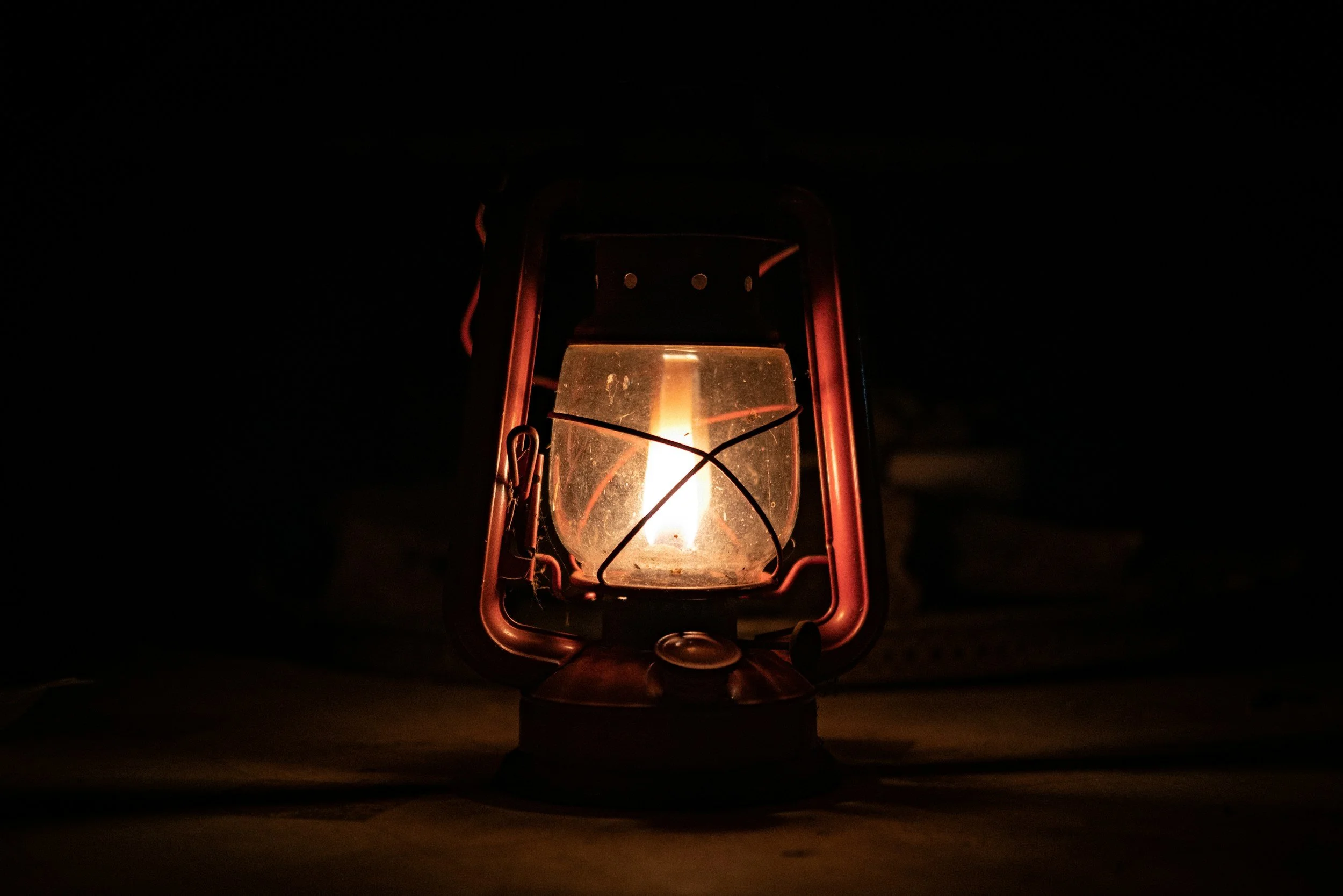 A lit lantern in a dark environment, with a warm glow emitting from the glass enclosure. This depicts light and results for Paid Social Media Advertising and running ads on platforms like Facebook, Instagram, YouTube. 