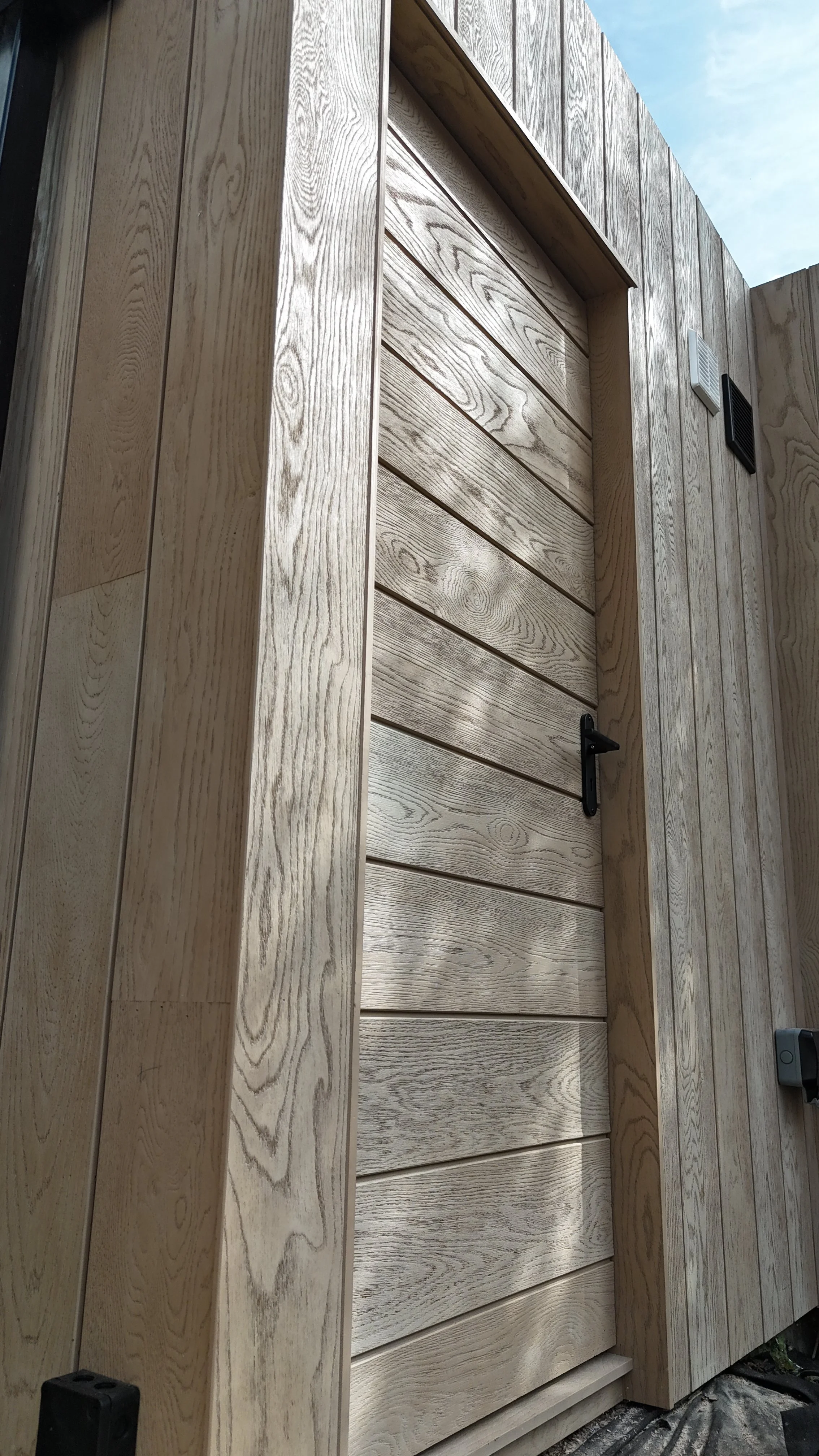 Millboard Envello Cladding in Golden Oak London.JPG