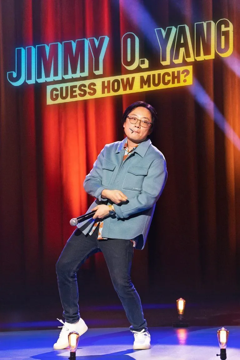 A comedian on stage performing, holding a microphone in one hand, with a colorful background that says 'Jimmy O. Yang, Guess How Much?'