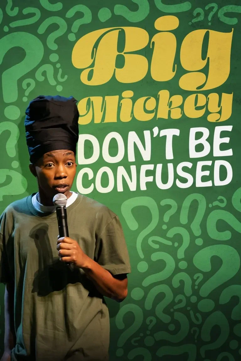 A comedian holding a microphone, standing in front of a green background with question marks and yellow, white, and green text that says "Big Mickey Don't Be Confused."