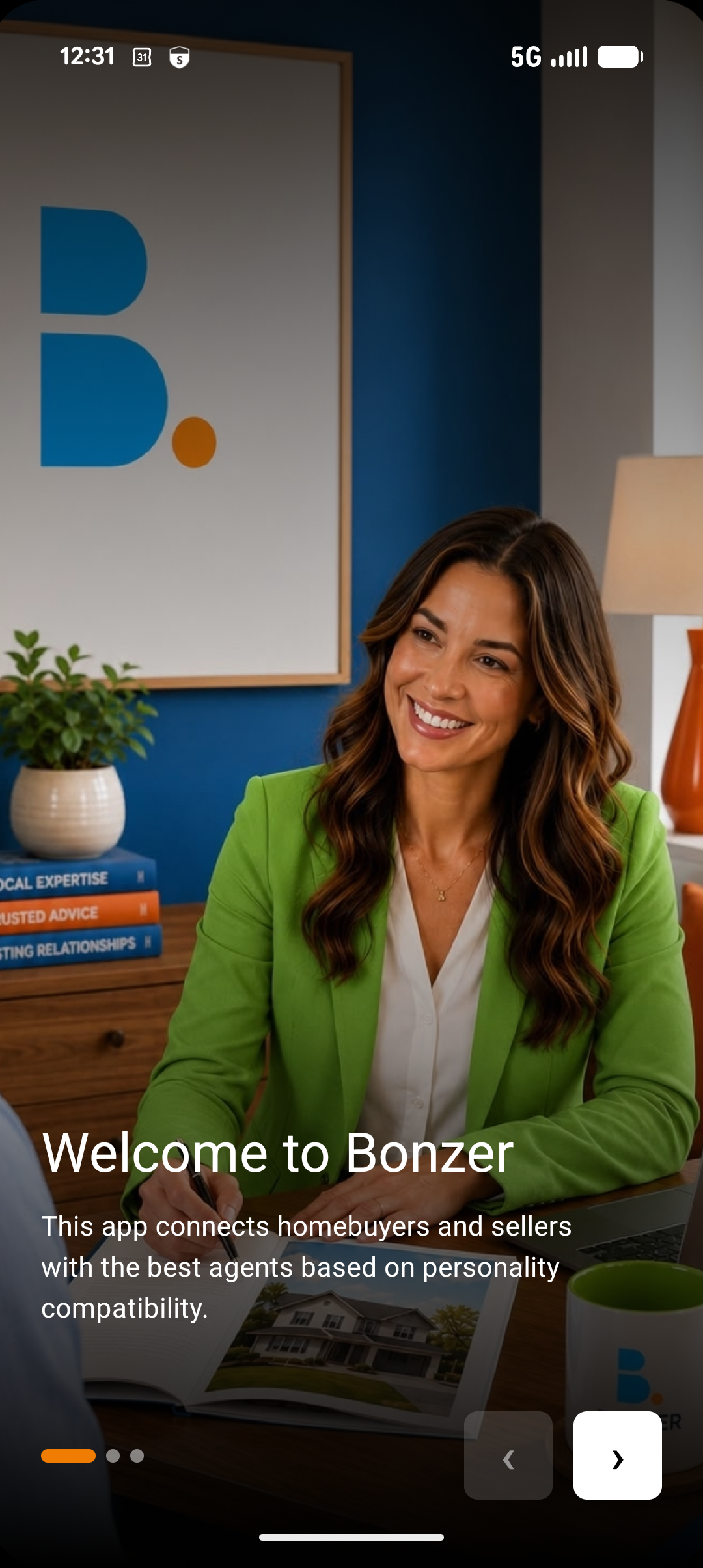 A woman in a green blazer sitting at a desk with a real estate brochure, smiling during a meeting. Behind her is a blue wall with a whiteboard and a framed letter "B" with a yellow dot, and a blue book titled "Local Expertise." The scene suggests a professional office environment.