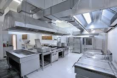 Commercial industrial kitchen with stainless steel appliances and countertops.