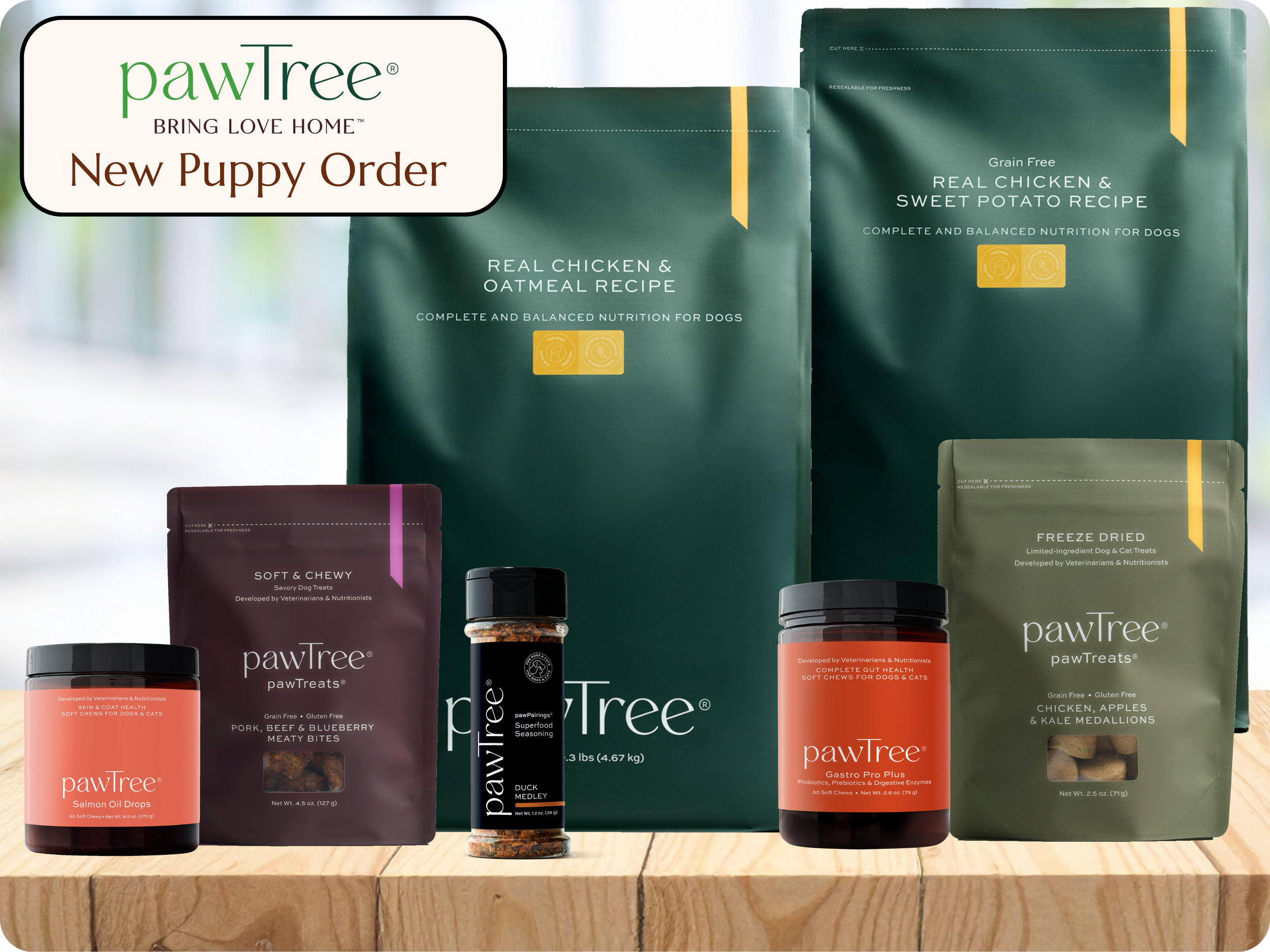 Display of various pawTree pet food and supplement products on a wooden surface. The packages include dog treats, soft chews, and other specialized pet health supplements from the PawTree brand.