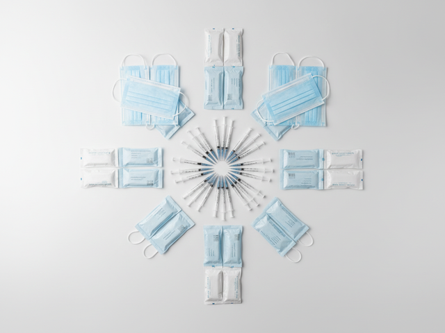 Medical masks and syringes arranged in a circle on a white background.