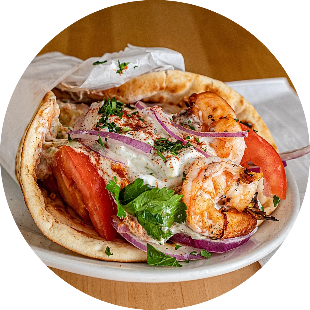 Shrimp taco with tomatoes, red onion, cilantro, and sauce in a soft shell