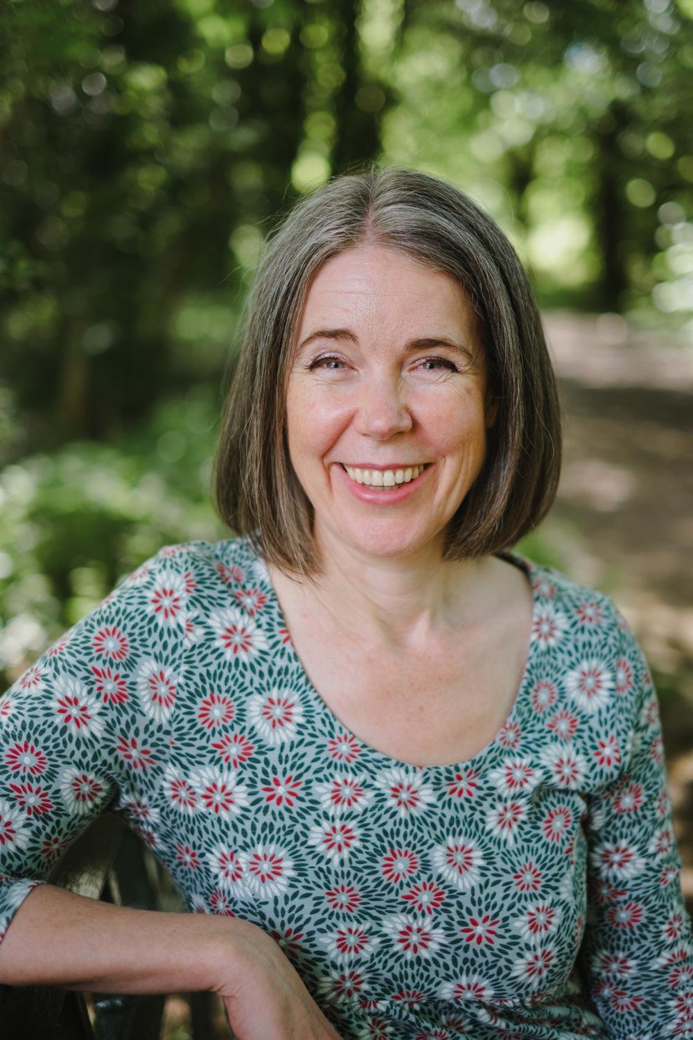 Nicola Pott, therapist, smiling warmly in an outdoor garden setting