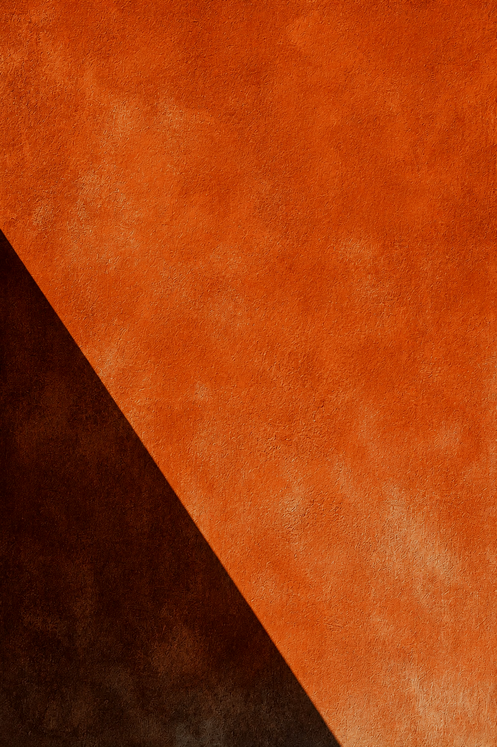 Close-up of orange and black textured surface with a diagonal division.