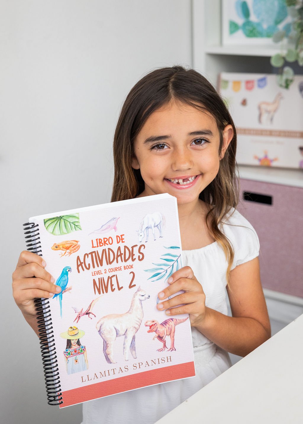 Smiling girl holding a colorful activity book with animals on cover