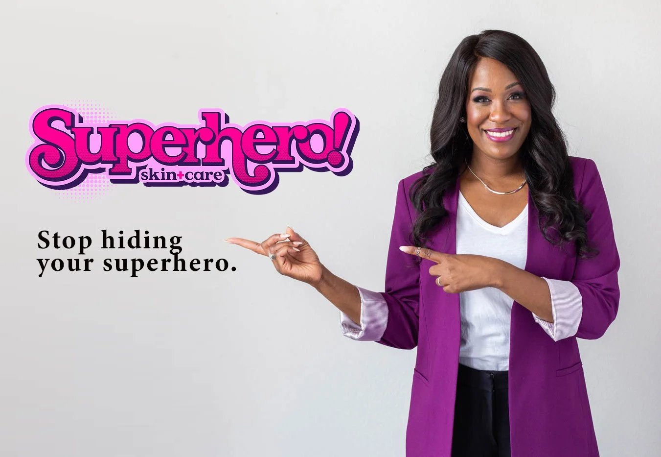 A woman in a purple blazer points to a logo for 'Superhero! skin+care' and the message 'Stop hiding your superhero' on a plain gray background.