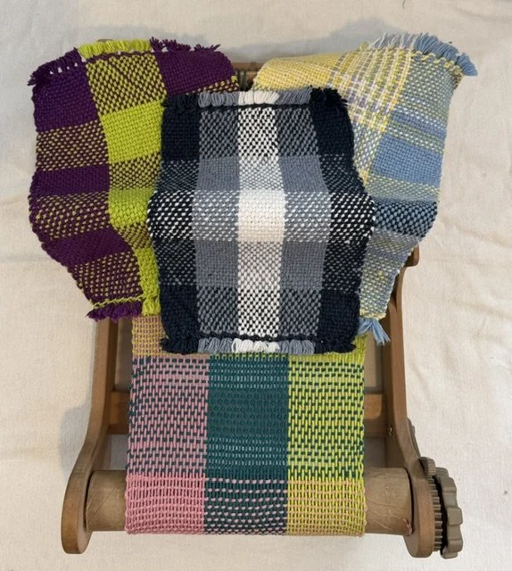 Colorful woven textile blankets with checkered patterns draped over a small wooden chair.