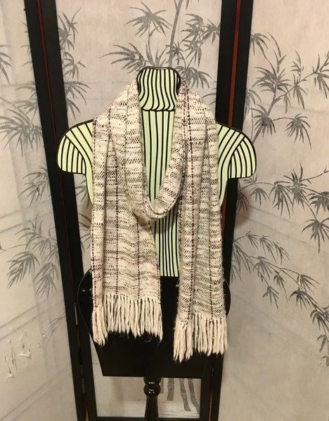 Mannequin with a striped shirt and a plaid scarf, standing in front of folding screen with bamboo pattern.